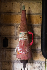 A vintage fire extinguisher, faded label and cone shaped