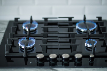 Cooktop with burning gas rings. Gas cooker with blue flames.