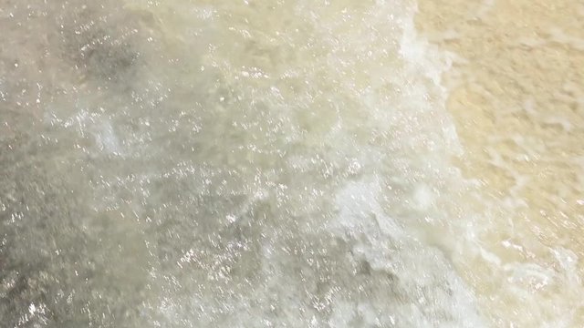 Background with Wave and Black and Yellow Sand. Close Up