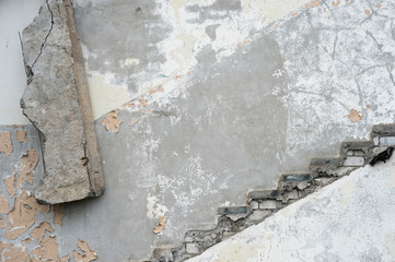 The gray wall of the house with the remains of the contour of the ladder, peeling paint and hanging...