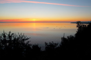 On the morning dawn on the surface of lake Baikal in the distance can be seen boats with fishermen – in this place in the summer a traditional place for fishing on the Baikal omul and grayling