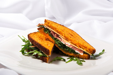 Meat sandwich with cheese and greens on a white background