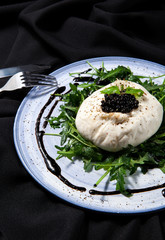 Burratta cheese with arugula, balsamic vinegar pearls and white wine on a dark background