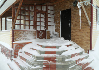 Entrance of  house in a snowdrift - obrazy, fototapety, plakaty