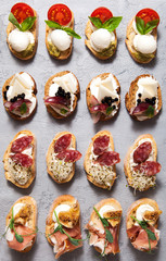 Different types of bruschetta on a gray concrete background
