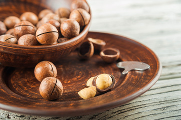 Macedonian nuts on a wooden plate on the background of a textural wooden table. Macedonian nuts close up and copy space