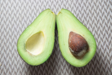 Avocado cut in half on decorative background
