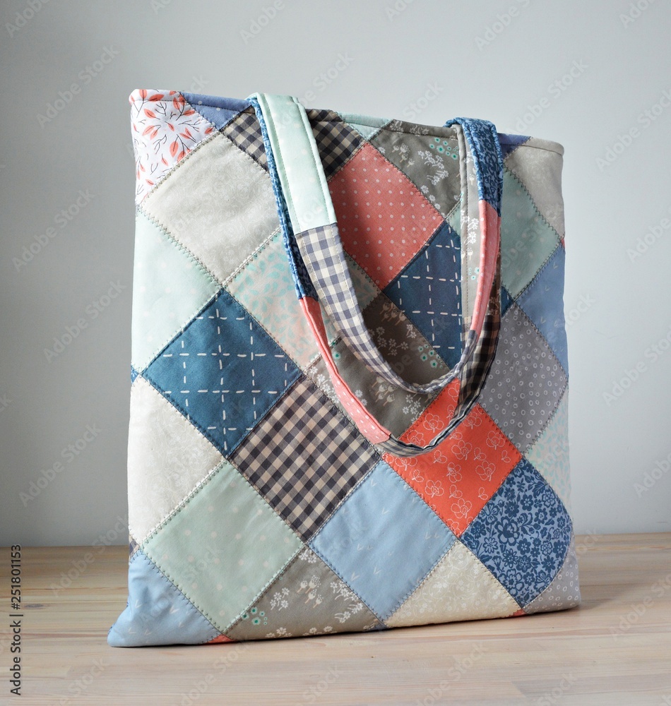 Wall mural Quilted tote bag on the wooden table