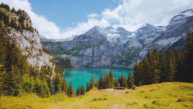 Idyllic view of the azure lake Oeschinensee. Location place Swiss alps, Kandersteg valley, Europe. Scenic footage of popular tourist attraction. Discover the beauty of earth. Shooting in 4K video.