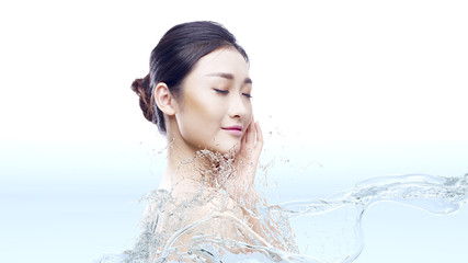 Naklejka premium beautiful young asian woman with perfect skin in splashes of water