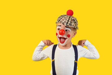 Portrait funny child.Cheerful boy,costume clown,red nose,makeup.Emotional face little comic...