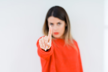 Young woman wearing casual red sweater over isolated background Pointing with finger up and angry expression