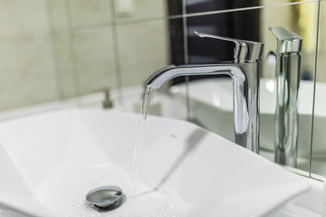 Interior of bathroom with sink basin faucet and mirror. Modern design of bathroom.