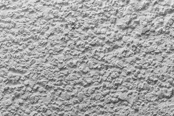 Black and white whitewashed concrete wall interspersed with stones