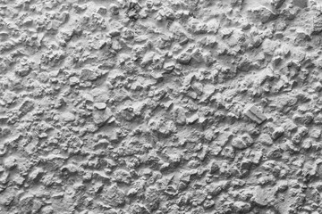 Black and white whitewashed concrete wall interspersed with stones