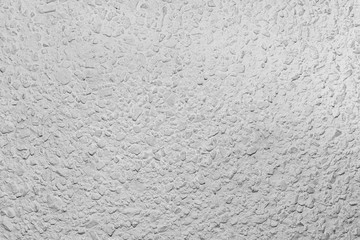 Black and white whitewashed concrete wall interspersed with stones