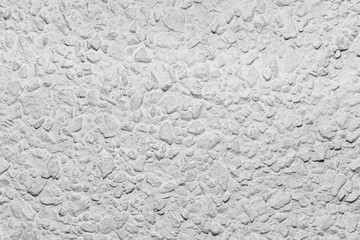 Black and white whitewashed concrete wall interspersed with stones