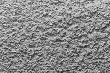 Black and white whitewashed concrete wall interspersed with stones