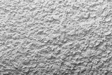 Black and white whitewashed concrete wall interspersed with stones