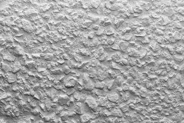 Black and white whitewashed concrete wall interspersed with stones