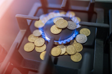 Cost of gas, concept crisis. Gas stove with coins in flame. The cost of methane. Gas coins more expensive, Payment