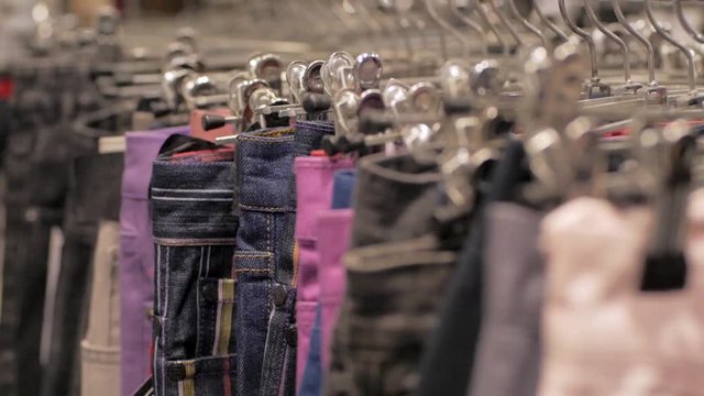 Close up of many jeans on a hanger in shop