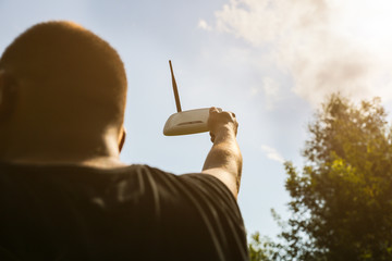 Man is looking for wi-fi signal in the nature. Guy is lost and holding router in his hands...