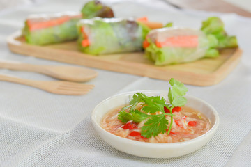 Salad roll with Green and red oaks, slice carrot, sausage, tuna on wooden tray with spicy dipping (Chili, Garlic and fish sauce). Healthy food.