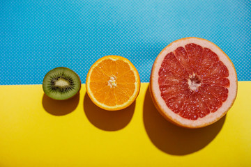 Different kinds of fruit on blue and yellow background.