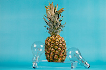 Different kinds of fruit and electric bulbs on blue background.