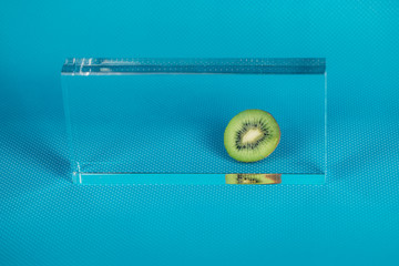 Kiwifruit behind plexiglass on blue background.