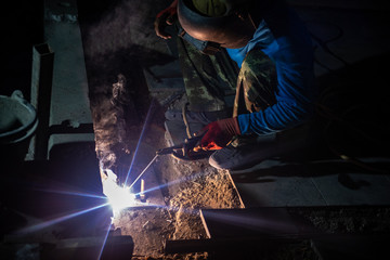 worker with protective mask welding metal