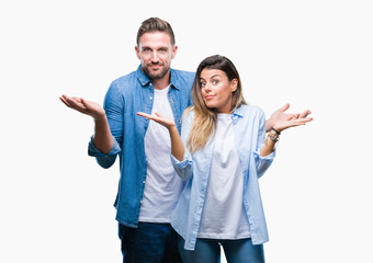 Young couple in love over isolated background clueless and confused expression with arms and hands...
