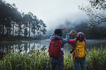 Couples who love to travel, take pictures Beatiful nature at Pang ung lake and pine forest at Mae Hong Son in Thailand. - obrazy, fototapety, plakaty