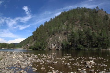 Siberian river Barguzin in the upper summer day in one of its turns between the slopes of the mountains