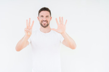 Naklejka premium Young handsome man wearing casual white t-shirt over isolated background showing and pointing up with fingers number eight while smiling confident and happy.