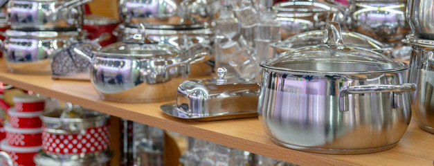Fototapeta na wymiar Stainless steel pans on the store shelf.