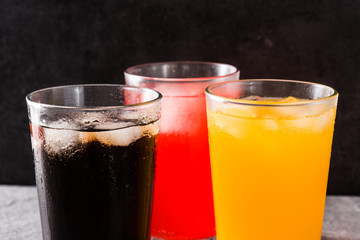 Colorful soft drinks for summer on gray background