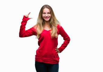 Obraz na płótnie Canvas Young beautiful blonde woman wearing red sweater over isolated background smiling and confident gesturing with hand doing size sign with fingers while looking and the camera. Measure concept.