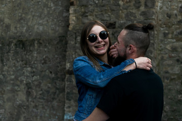 Mann hält seine Freundin im Arm, beide lachen