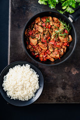 Chicken vegetable pan with rice, fresh ingredients and herbs