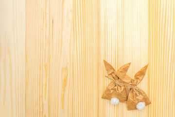 Easter bunny (rabbit) paper gift wrapping idea. Handicraft (homemade) concept for children (kids). On wooden background, top view