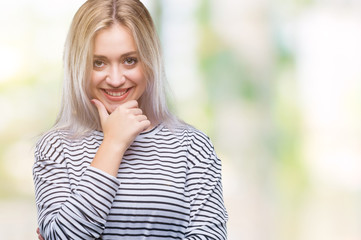 Fototapeta na wymiar Young blonde woman over isolated background looking confident at the camera with smile with crossed arms and hand raised on chin. Thinking positive.