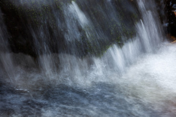 Fototapeta na wymiar Water flowing over rocks in creek