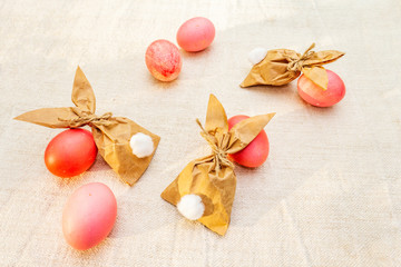 Fototapeta na wymiar Easter bunny (rabbit) paper gift egg wrapping idea. Handicraft (homemade) concept for children (kids). On vintage cloth (linen) background