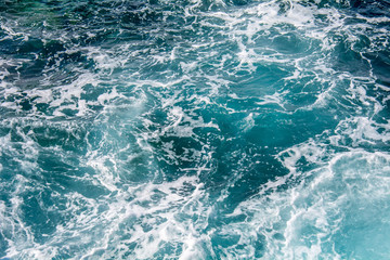 Fototapeta na wymiar Blue sea water with white foam