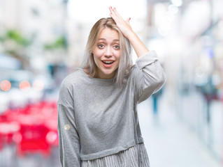 Young blonde woman over isolated background surprised with hand on head for mistake, remember error. Forgot, bad memory concept.