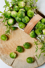 Brussels sprout - vegetable culture. Small kochanchik in a basket on a wooden background. Soft focus.