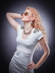fashionable blonde woman in sunglasses . isolated on a dark