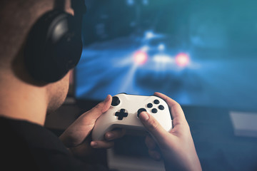 Man holding game pad and playing car race game